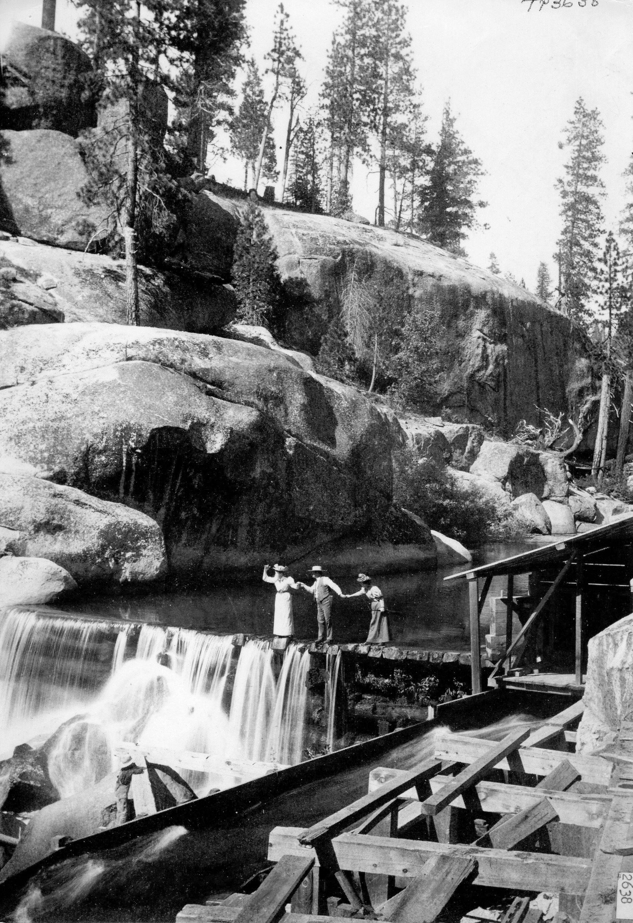 people standing above waterfall