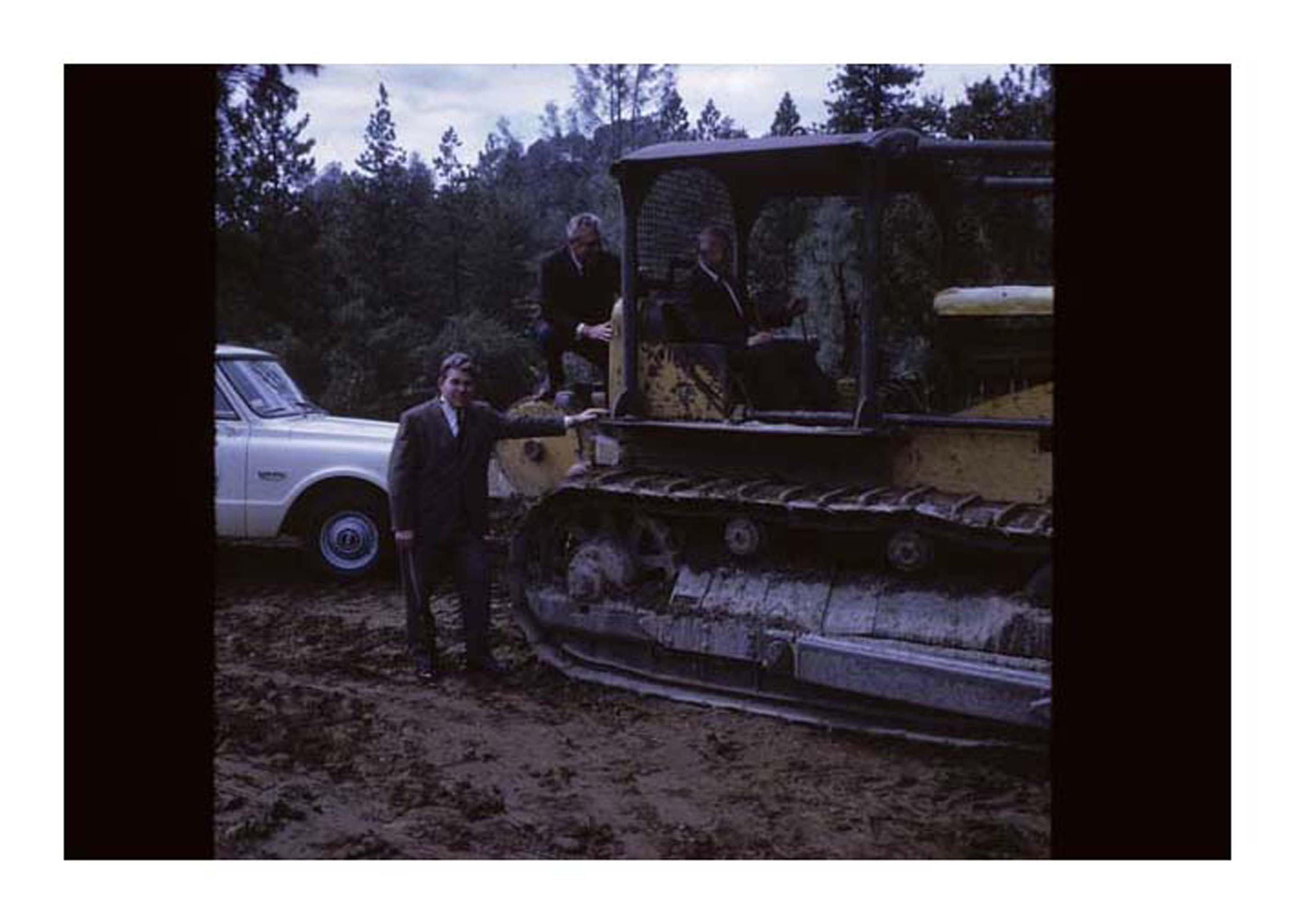 person on tractor next to person standing next to tractor