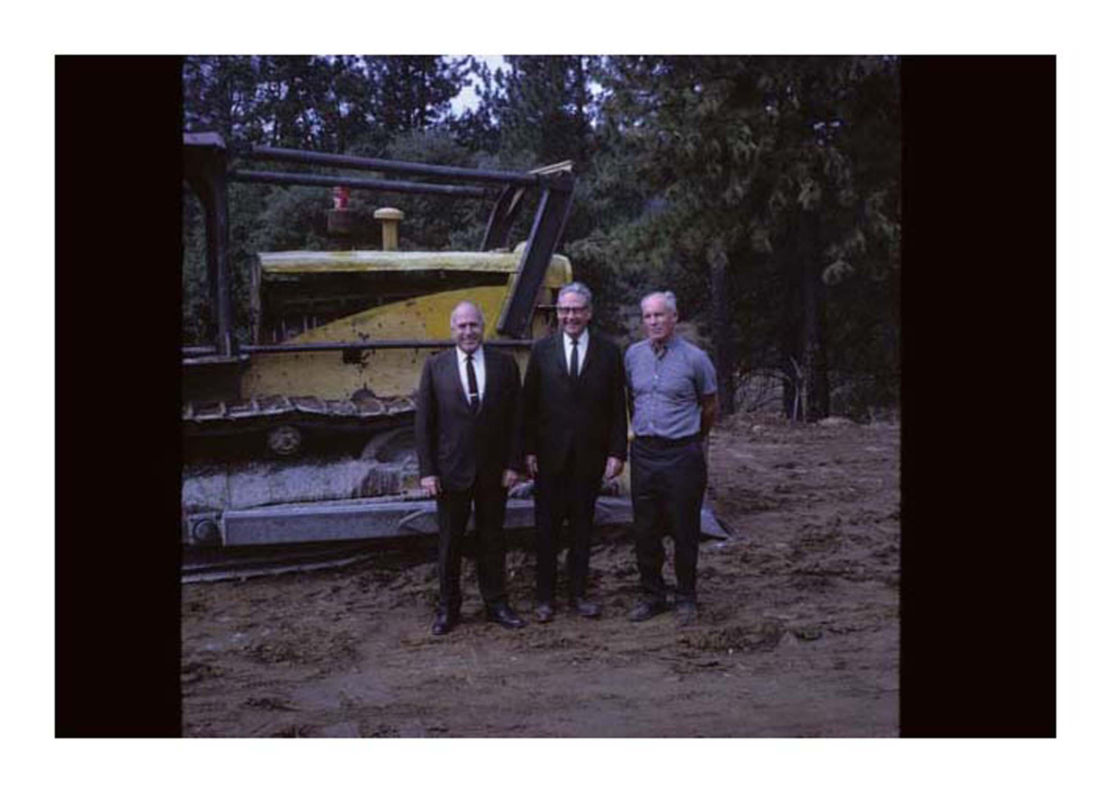 group of 3 infront of tractor