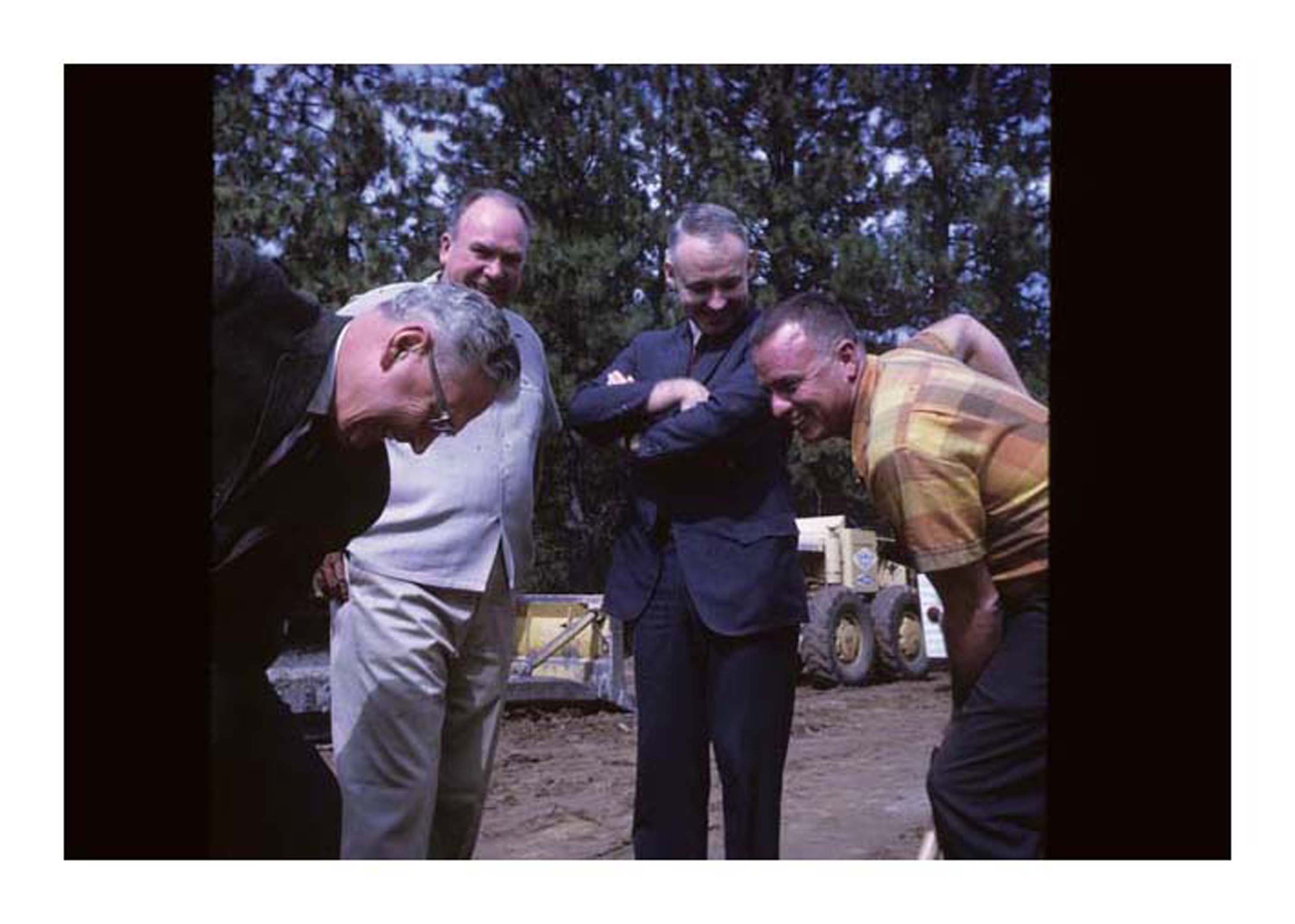 2 people digging for camera