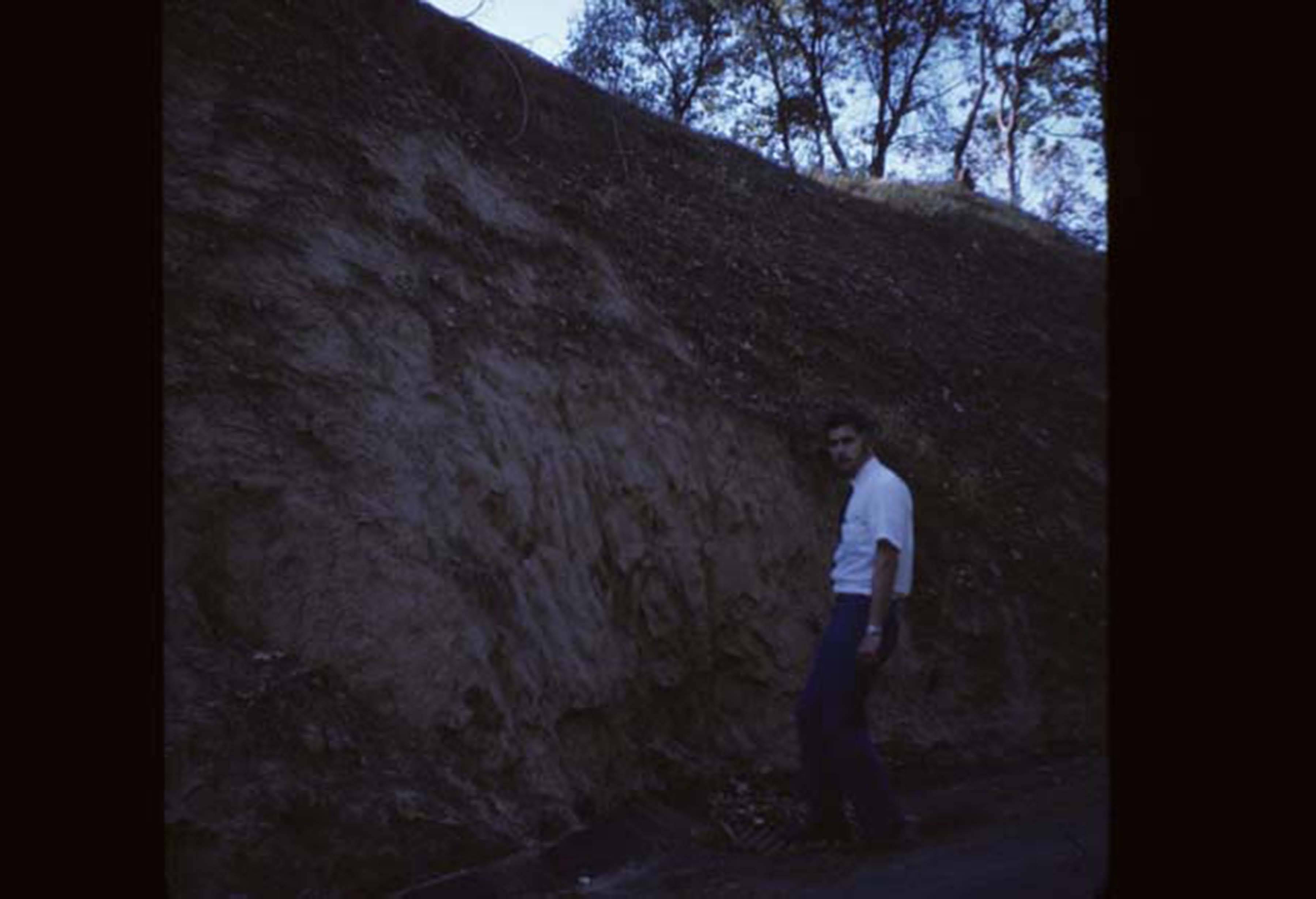 man standing next to hill