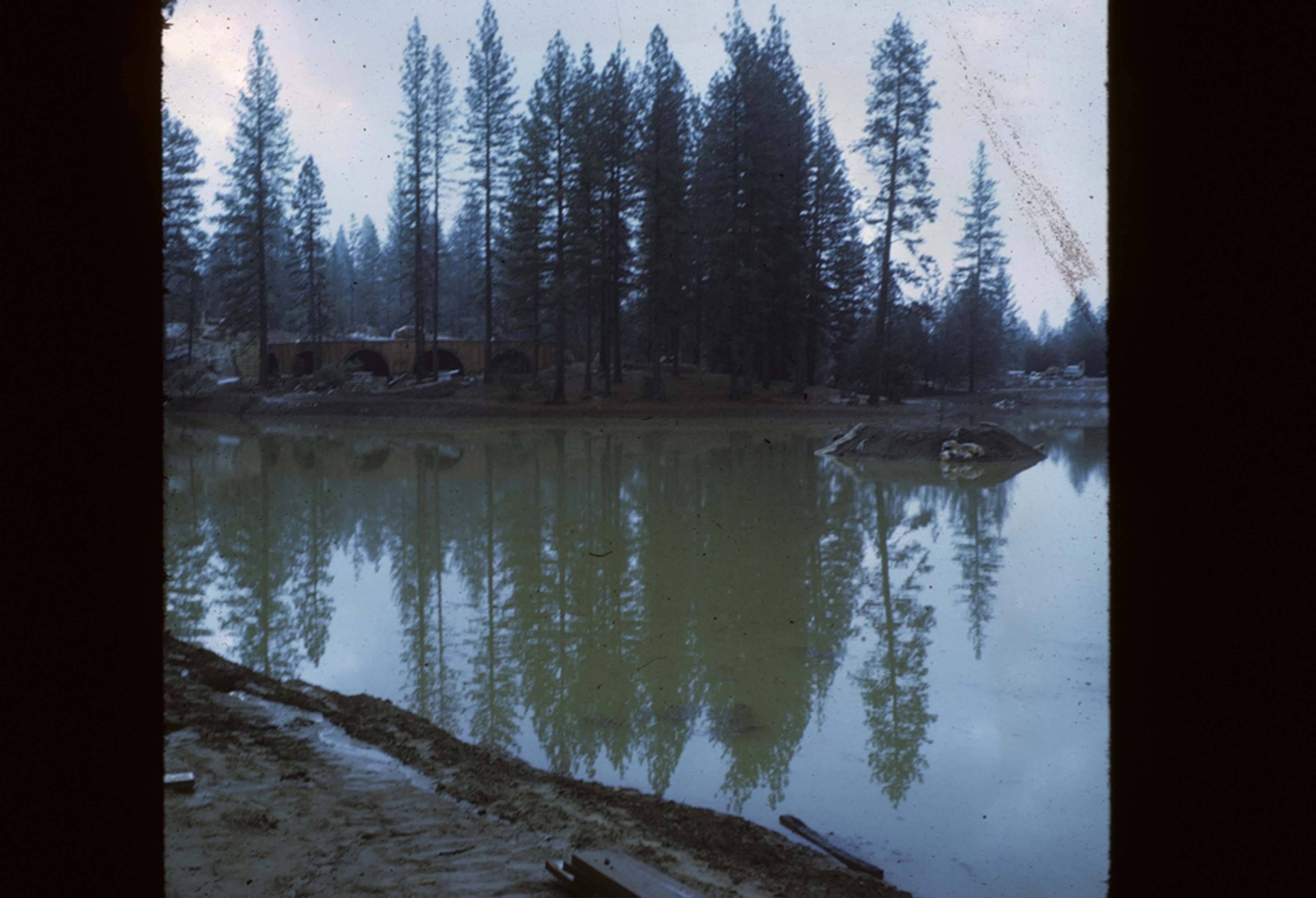Lake partially filled with manzanita construction in background