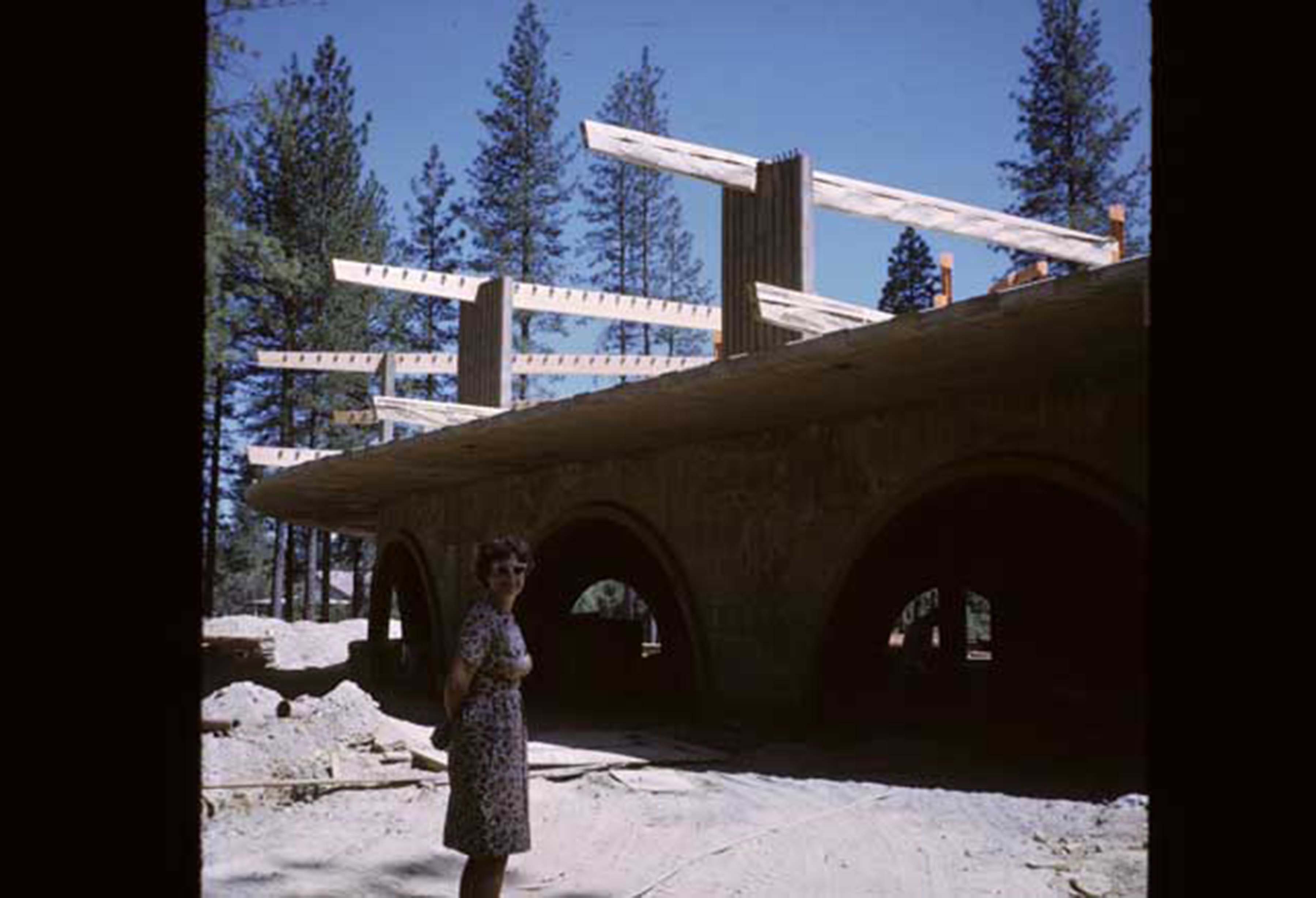 person smiling in foreground of construction site of manzanita
