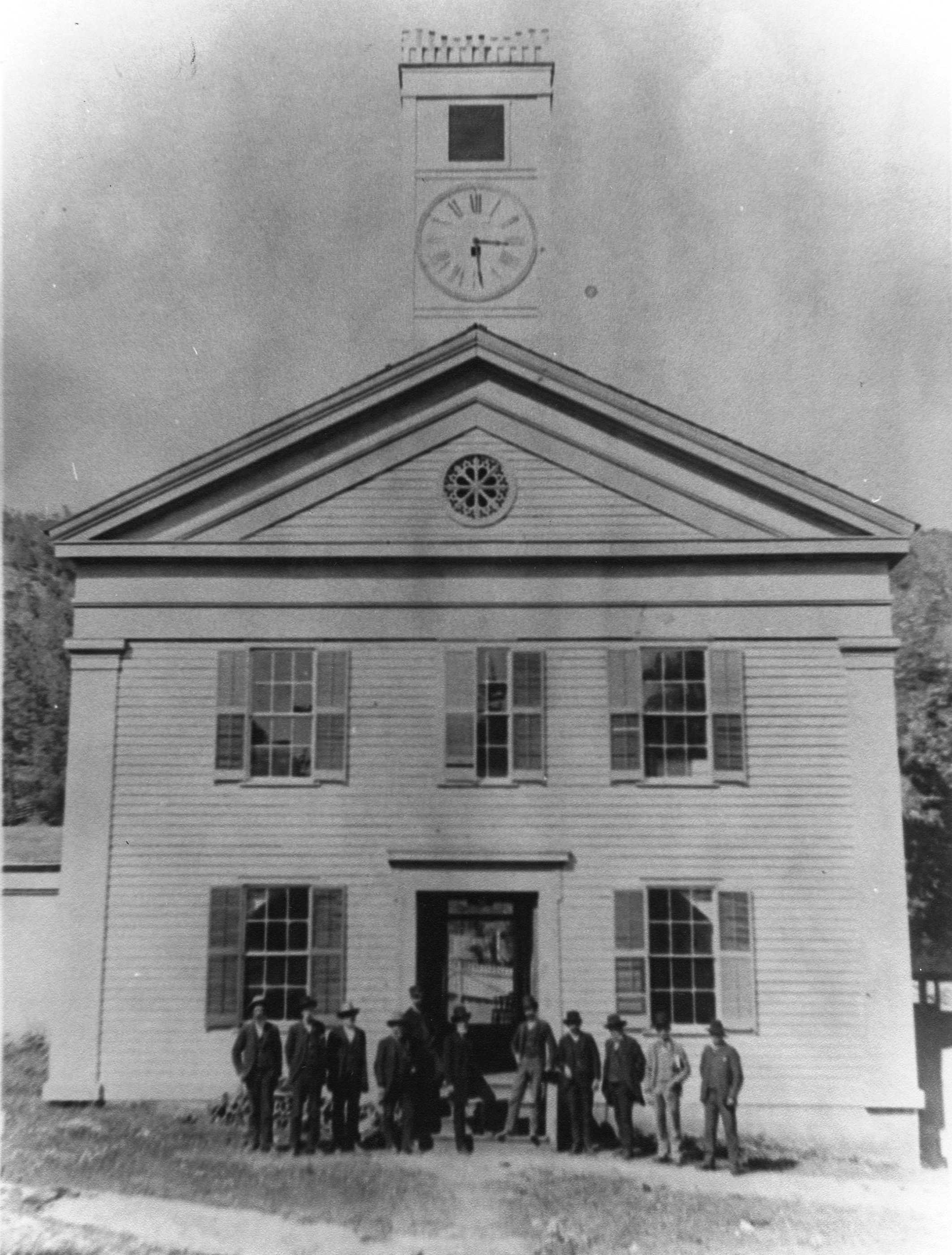 people in front of building with clock tower
