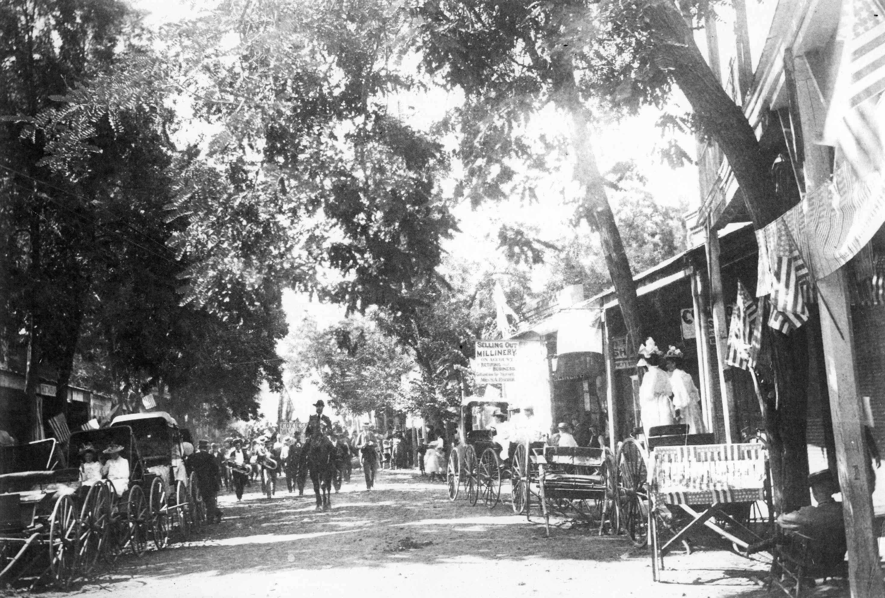 people on horses walking down road